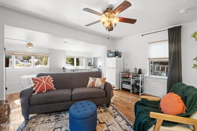 a living room with furniture kitchen view and a chandelier