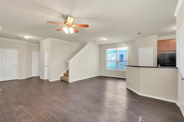 a view of an empty room with window and wooden floor