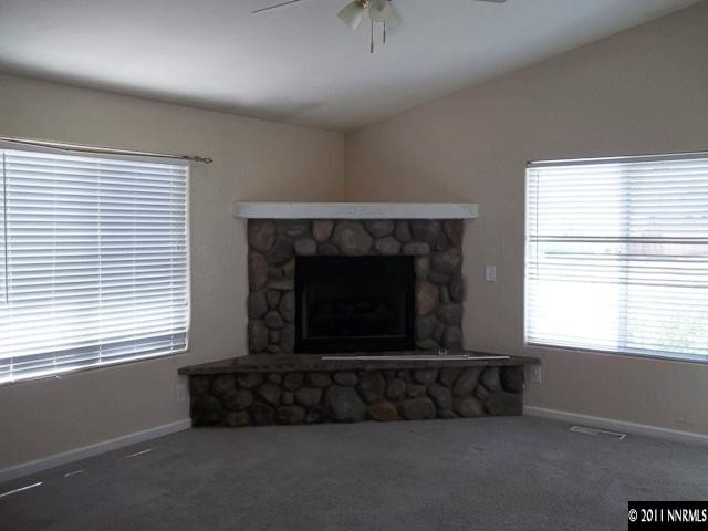 391 B Bens Way Fernley, NV 89408 - Photo 2 of 10 an empty room with a fireplace and windows