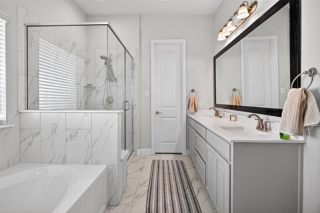 6829 Danridge Road Rowlett, TX 75089 - Photo 12 of 28 a bathroom with a sink a mirror and a bathtub