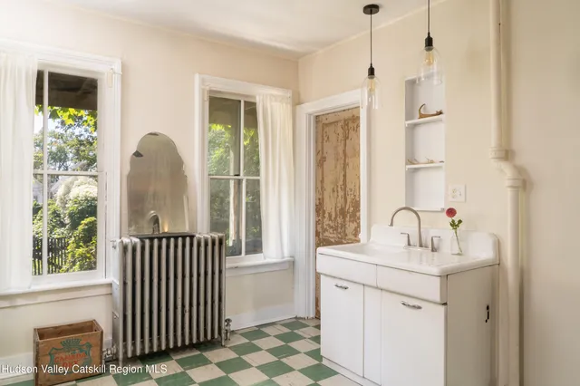 a kitchen with stainless steel appliances a stove a refrigerator a sink and white cabinets