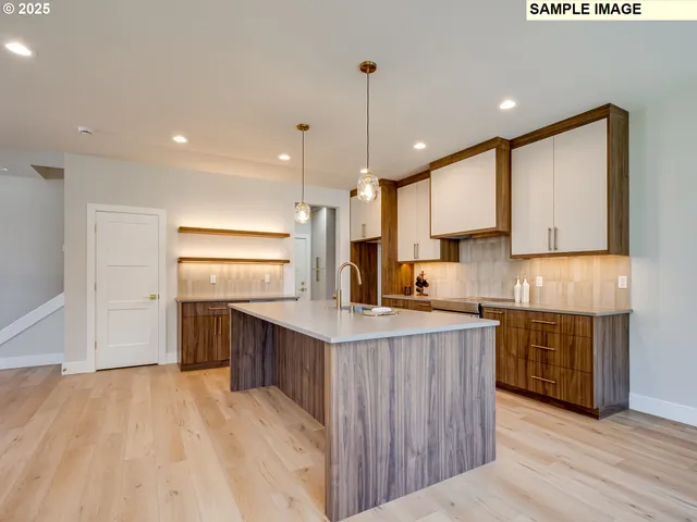 a kitchen with kitchen island a sink stainless steel appliances and cabinets
