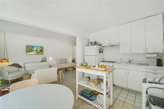 a utility room with stainless steel appliances a stove a sink and a refrigerator