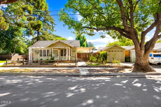 a front view of a house with a garden and trees