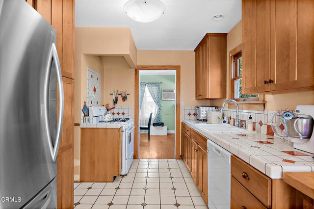 a kitchen with stainless steel appliances a sink stove and cabinets
