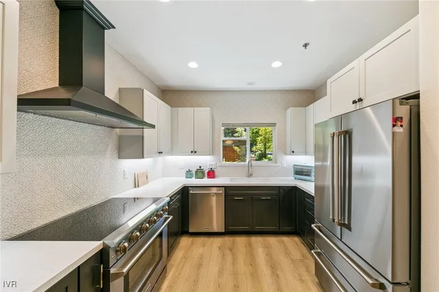 a kitchen with stainless steel appliances a sink window and cabinets