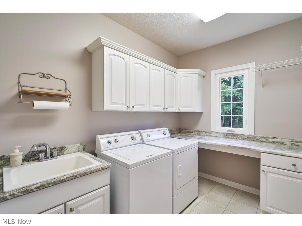 726 Sunridge Road Fairlawn, OH 44333 - Photo 12 of 28 First floor laundry room with white cabinetry and leather granite counter tops, and a stationary tub!