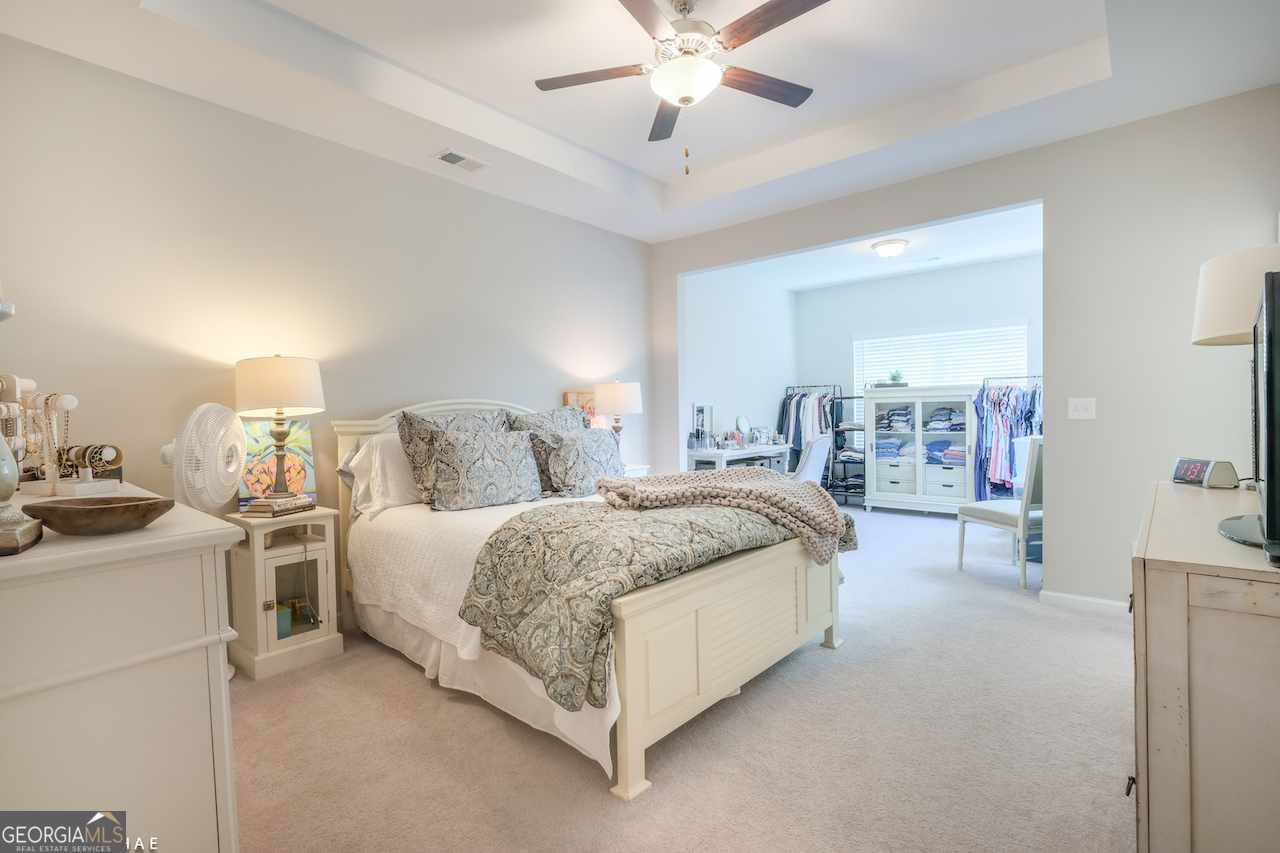 2247 Pink Hawthorn Drive Buford, GA 30518 - Photo 16 of 43 a spacious bedroom with a bed and a chandelier