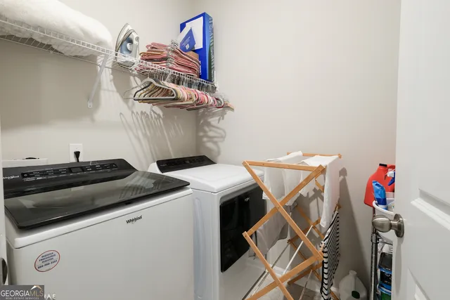 a utility room with dryer washer and stair