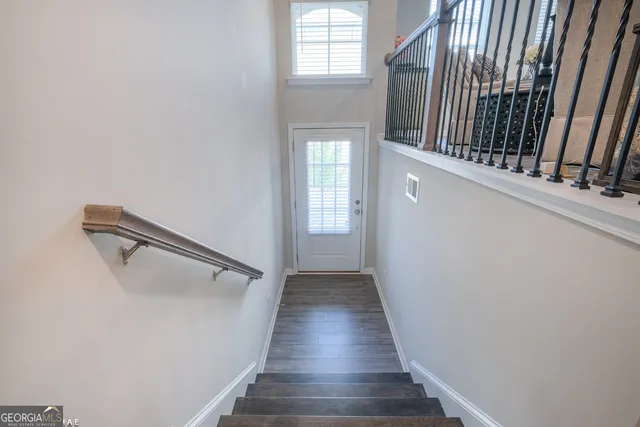 a view of a hallway with wooden floor and staircase