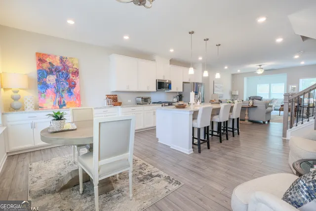 a living room with stainless steel appliances furniture and wooden floor