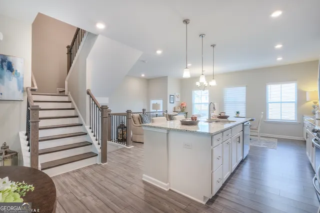 a kitchen with counter top space view wooden floor and staircase