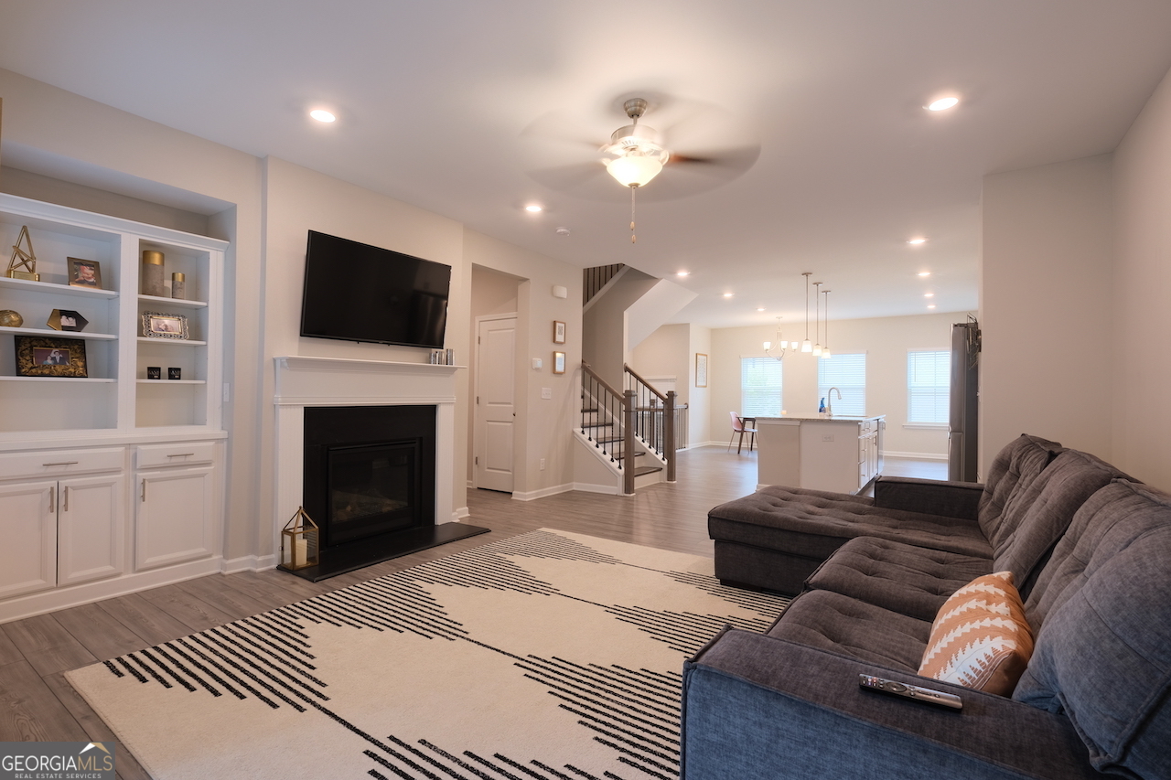 2247 Pink Hawthorn Drive Buford, GA 30518 - Photo 5 of 43 a living room with furniture a fireplace and a flat screen tv