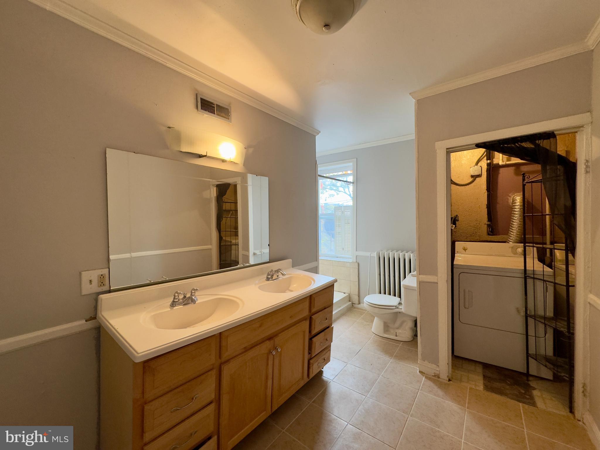 665 Portland Street Baltimore, MD 21230 - Photo 13 of 19 a bathroom with a sink a toilet and mirror