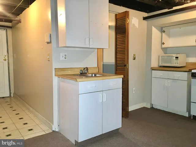a kitchen with granite countertop a refrigerator stove and sink