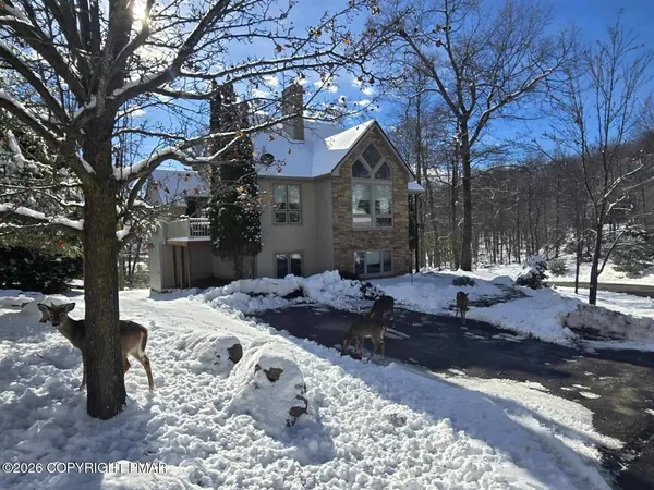 a front view of a house with a yard covered in snow
