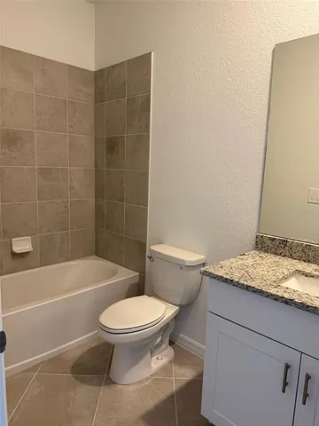 a white toilet and tub next to a bathroom sink