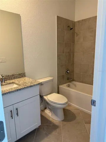 a bathroom with a granite countertop toilet a sink and bathtub