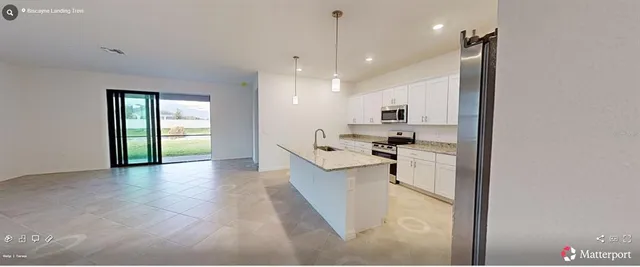 a view of a kitchen with kitchen island granite countertop a refrigerator and a sink