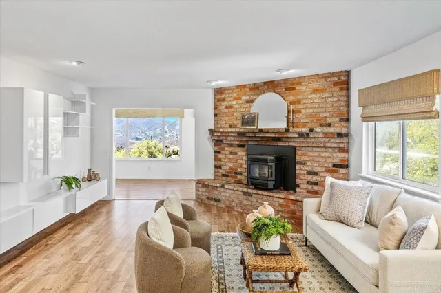 a living room with furniture a fireplace and a large window
