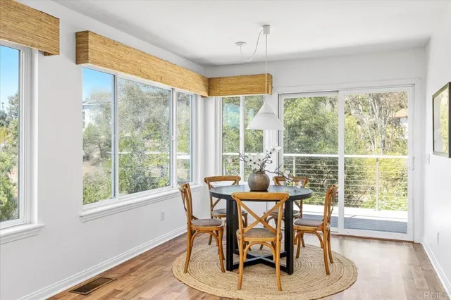 a dining room with furniture window and wooden floor