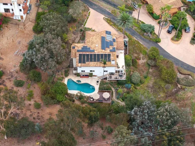 an aerial view of a house with swimming pool and a yard