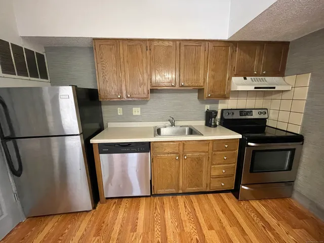 a kitchen with a refrigerator sink and cabinets
