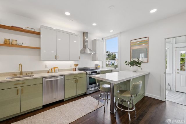 a kitchen with a sink and chairs