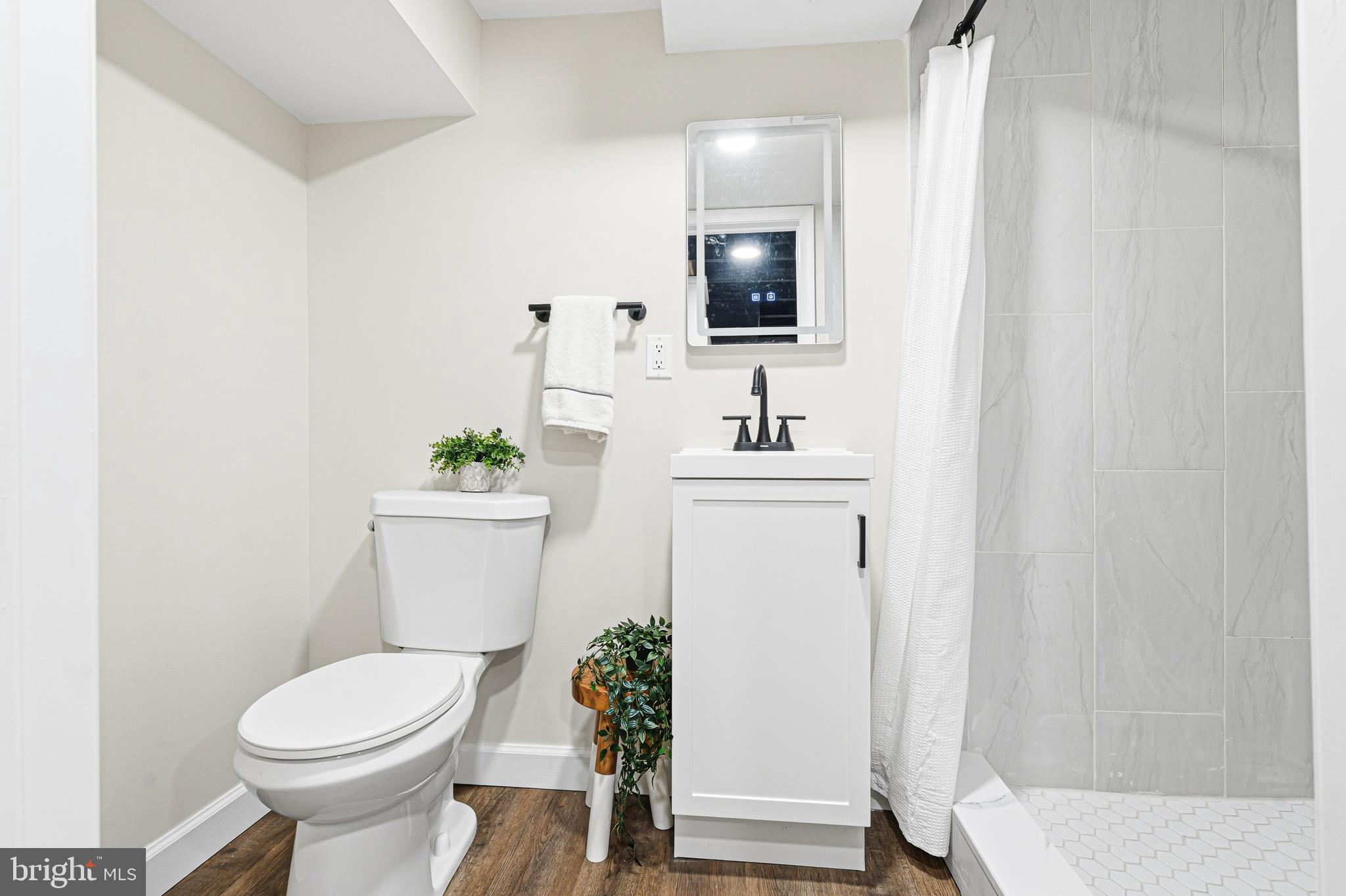 1326 Tompkins Street Baltimore, MD 21225 - Photo 15 of 34 a bathroom with a toilet sink and mirror