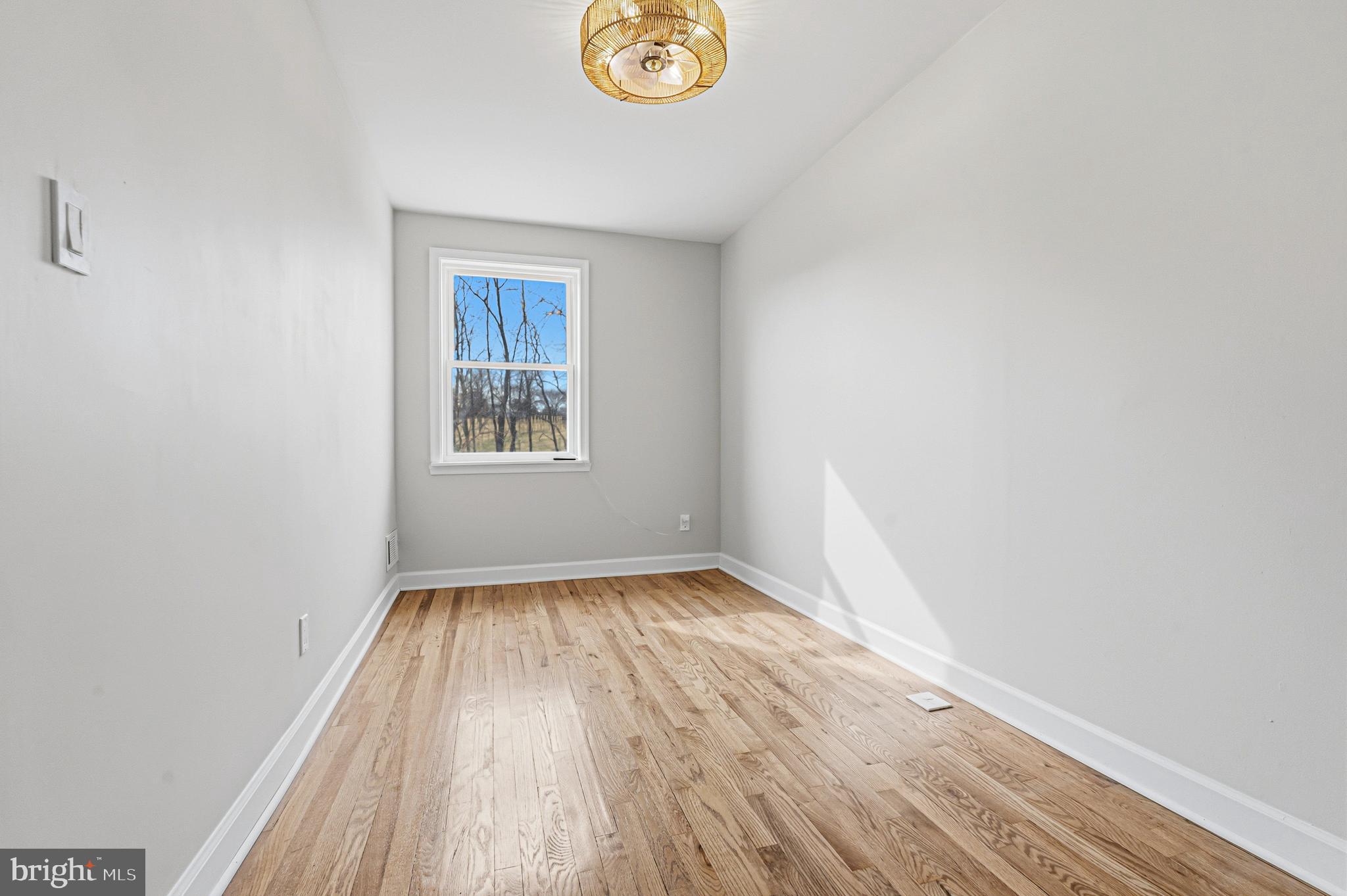 1326 Tompkins Street Baltimore, MD 21225 - Photo 21 of 34 a view of an empty room with window and wooden floor