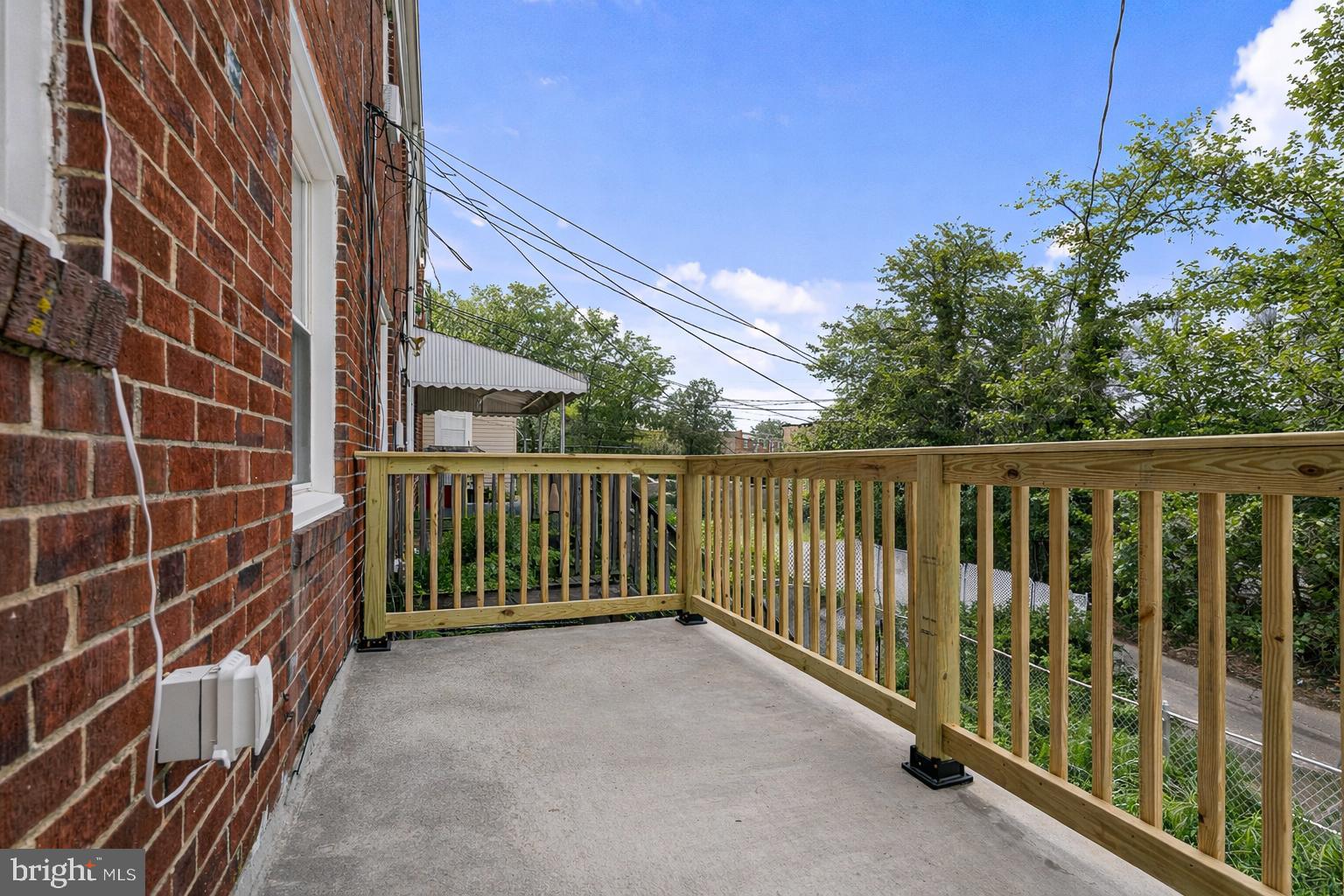 1326 Tompkins Street Baltimore, MD 21225 - Photo 32 of 34 a view of a balcony with a floor to ceiling window and wooden fence