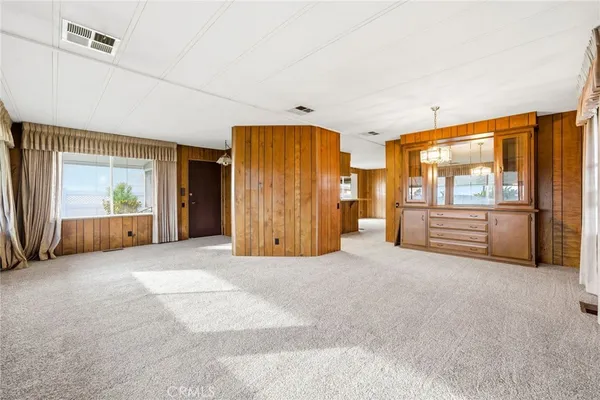 a view of an empty room with a fireplace and windows