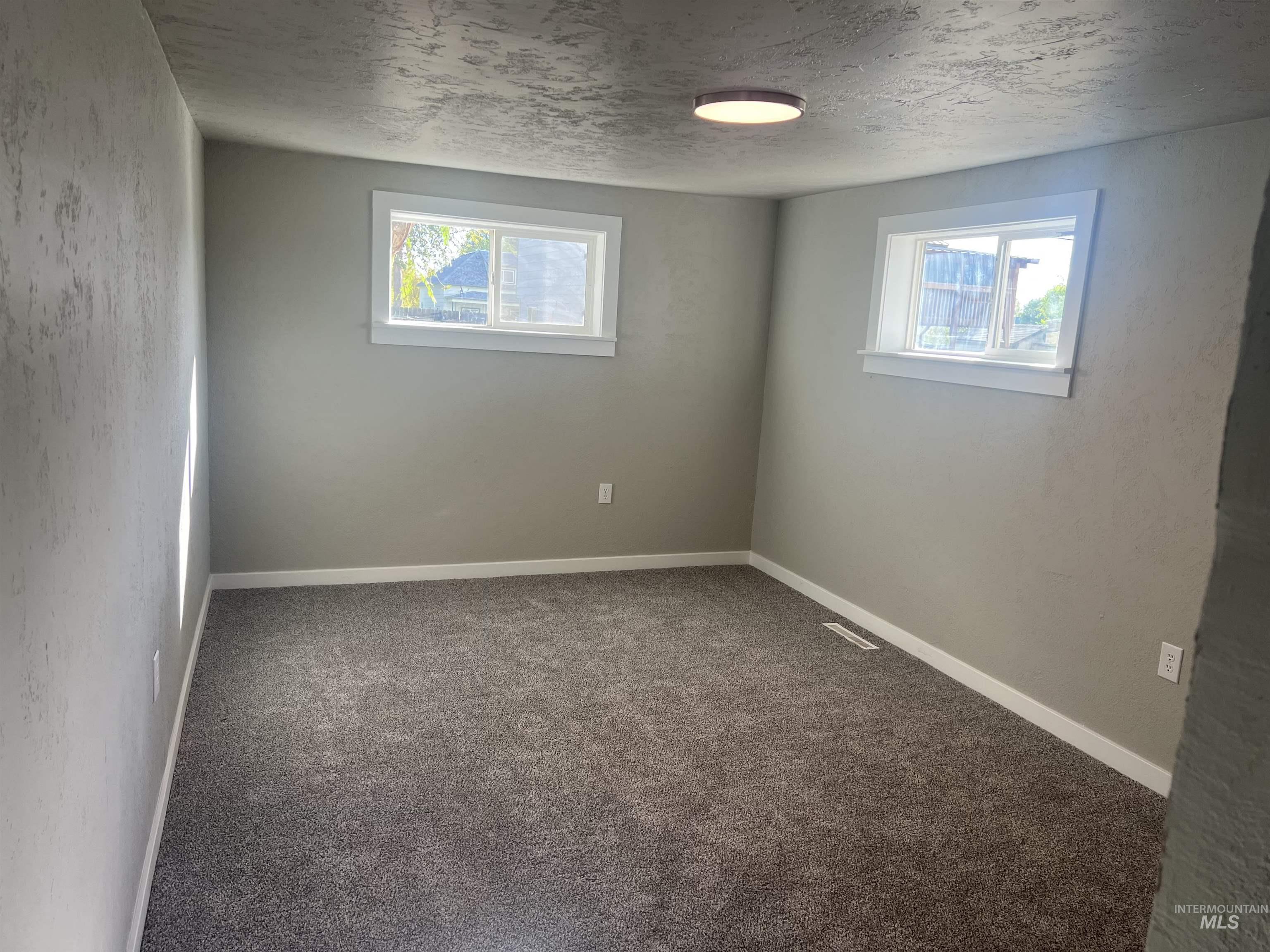 150 Roosevelt Street Mountain Home, ID 83647 - Photo 11 of 16 Carpeted empty room featuring a textured ceiling and a textured wall