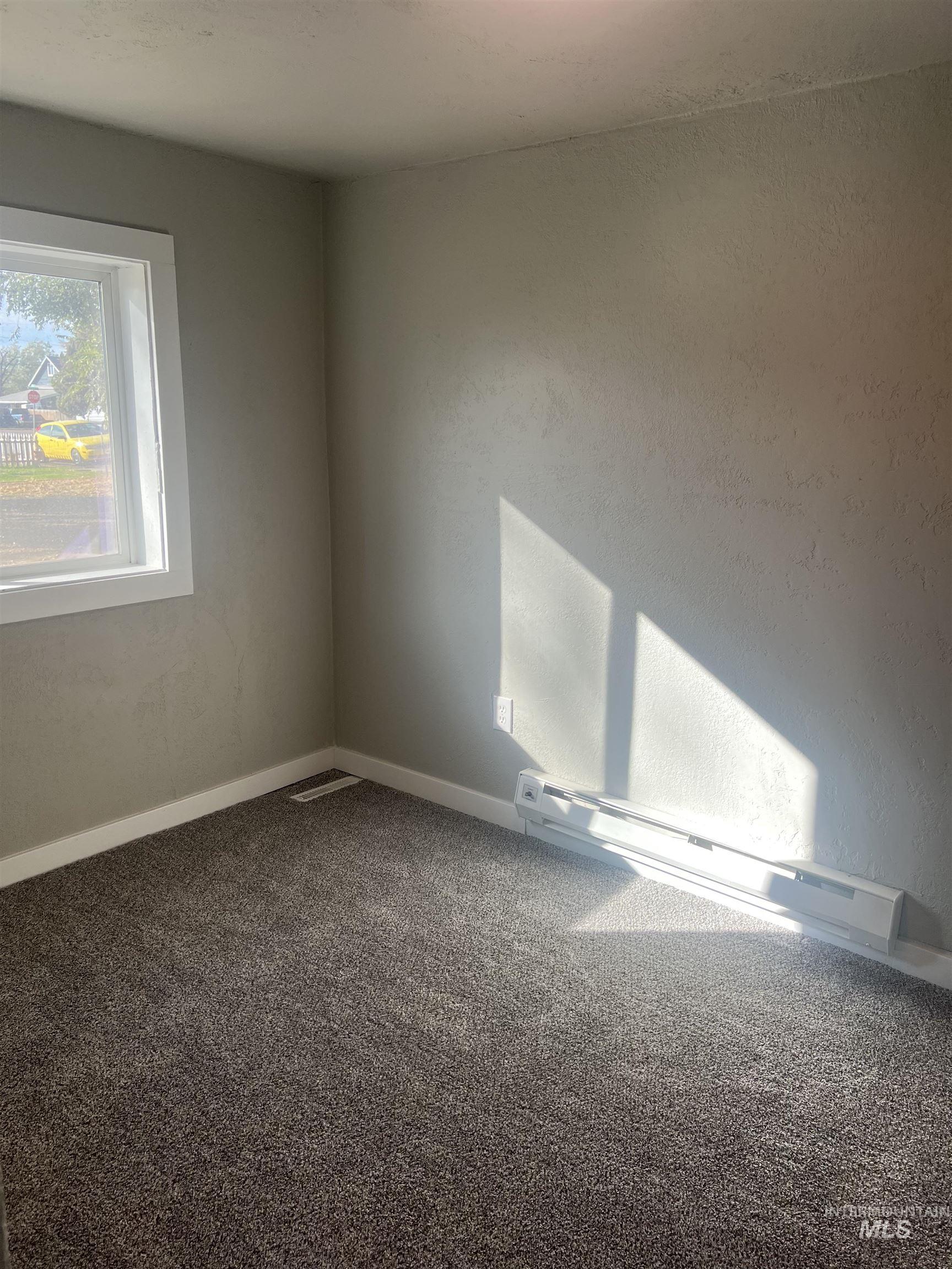 150 Roosevelt Street Mountain Home, ID 83647 - Photo 10 of 16 Carpeted empty room with a baseboard heating unit and baseboards