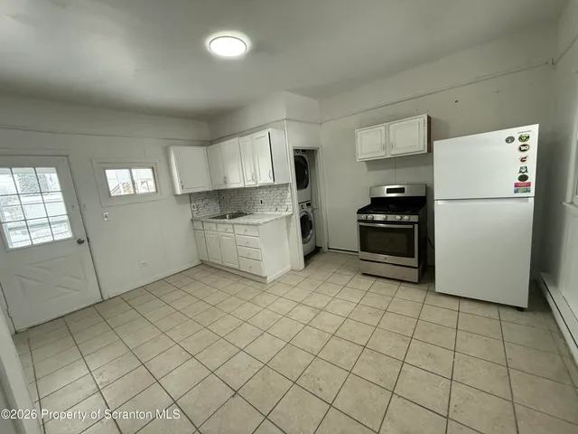 a kitchen with granite countertop a refrigerator and a stove top oven