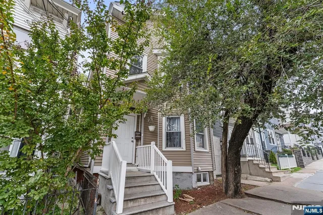 a view of a large house with a tree