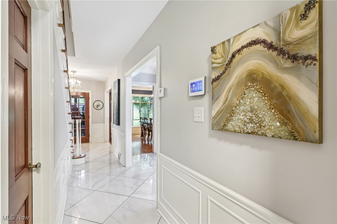 75 North Wheaton Road Akron, OH 44313 - Photo 12 of 40 Hall featuring a decorative wall, wainscoting, and a chandelier