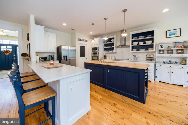 a kitchen with stainless steel appliances white cabinets and a wooden floor