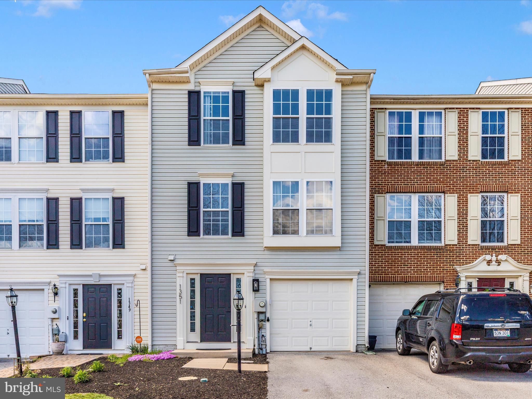a front view of a building with lot of cars and trees
