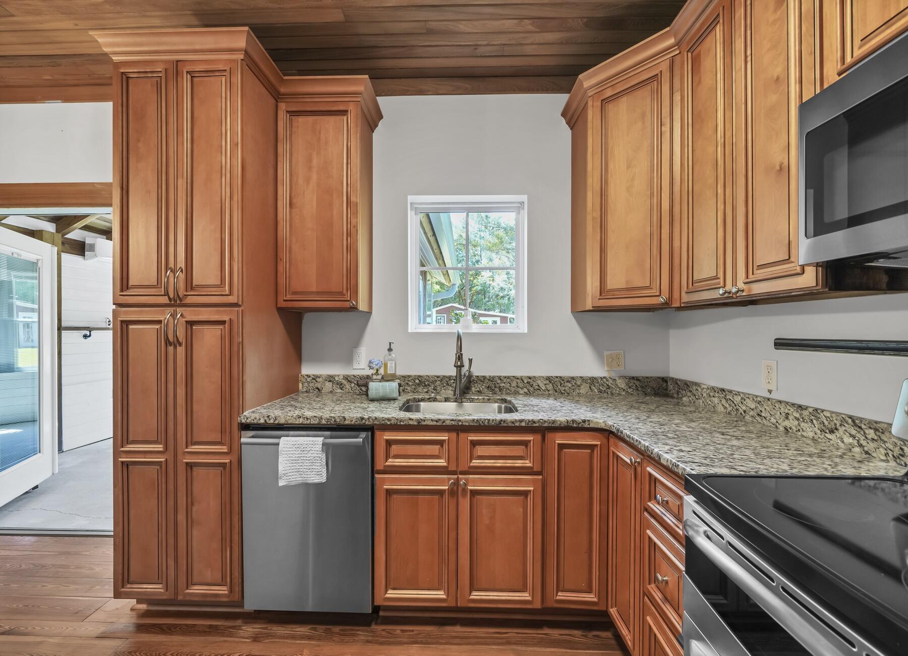 132 Hammock Oaks Boulevard Freeport, FL 32439 - Photo 17 of 45 a kitchen with stainless steel appliances granite countertop wooden cabinets a sink and a dishwasher