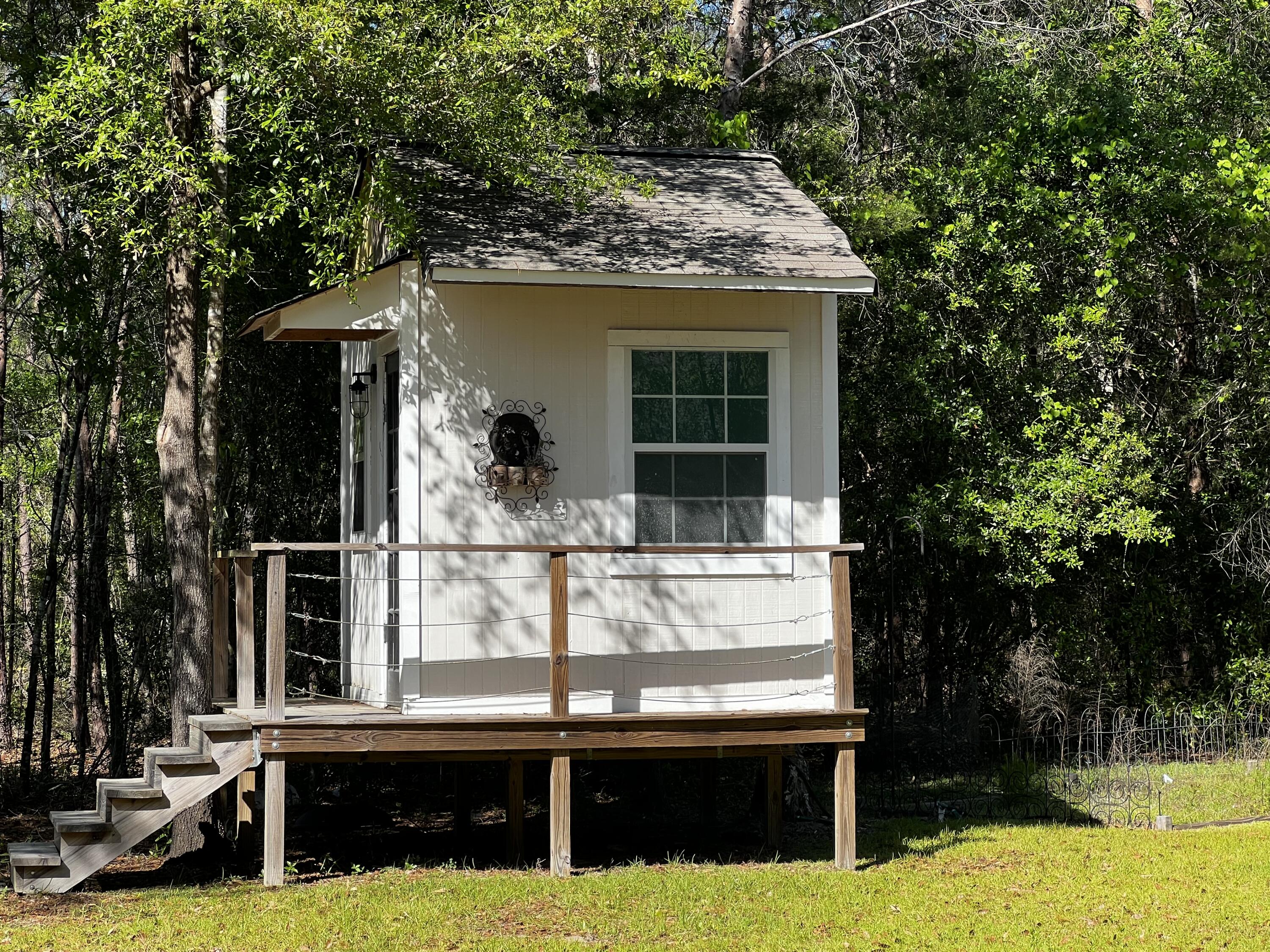 132 Hammock Oaks Boulevard Freeport, FL 32439 - Photo 45 of 45 a view of a house with large windows and a small yard