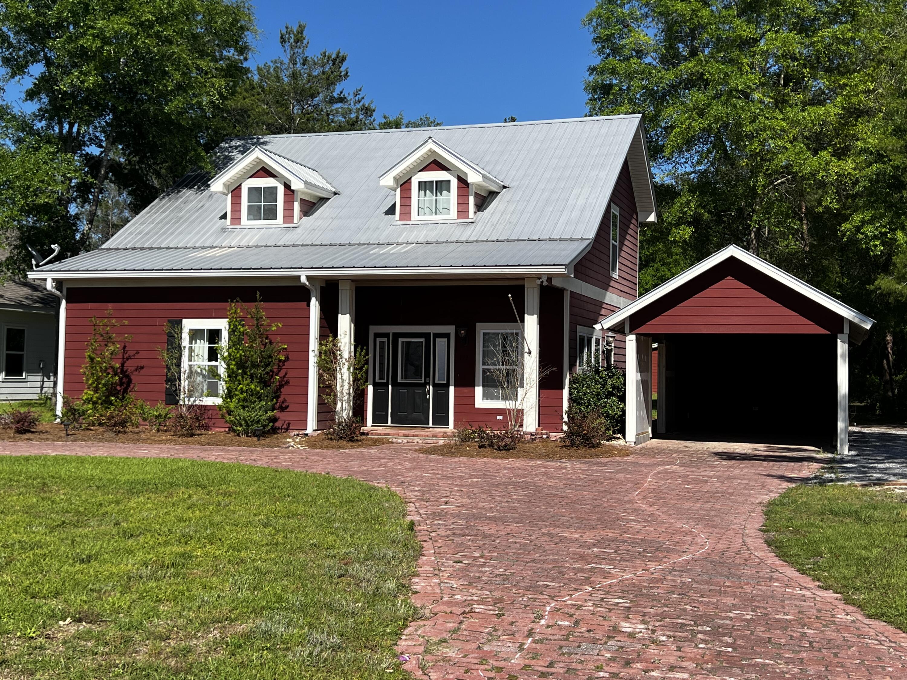 132 Hammock Oaks Boulevard Freeport, FL 32439 - Photo 5 of 45 a front view of a house with a yard table and chairs