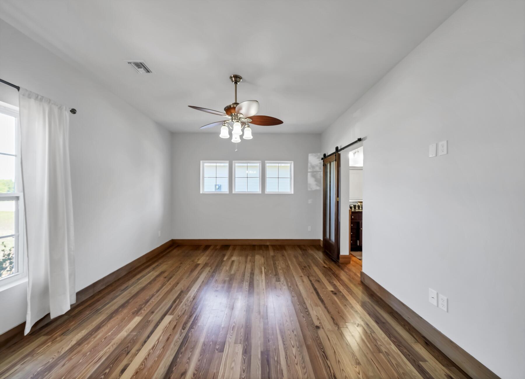 132 Hammock Oaks Boulevard Freeport, FL 32439 - Photo 7 of 45 wooden floor in an empty room with a window