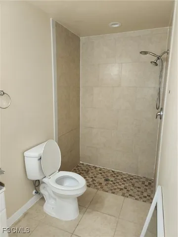 a white toilet sitting next to a shower