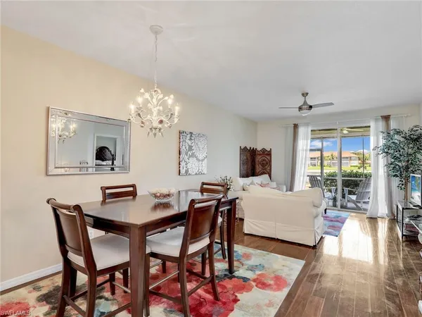 a dining room with furniture a chandelier and wooden floor