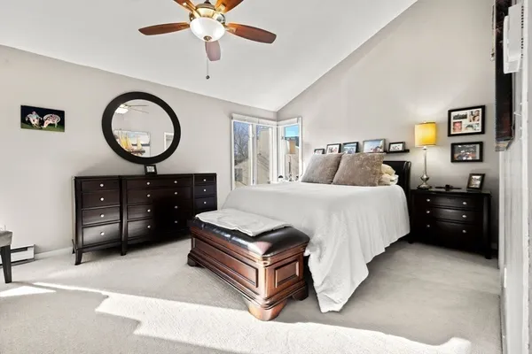 a bedroom with a bed a flat screen tv and a chandelier