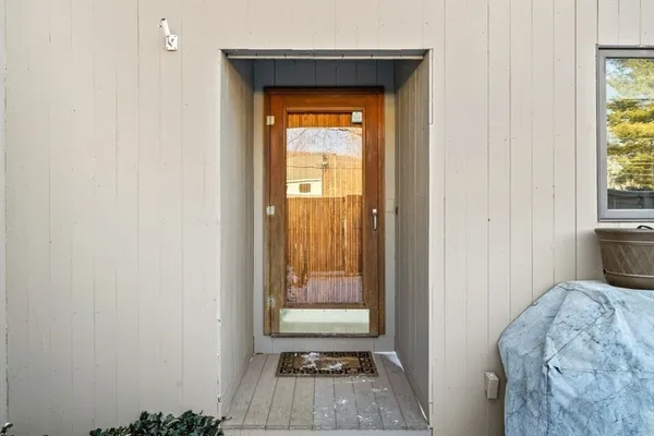 a living room with stainless steel appliances cabinets and a wooden floor
