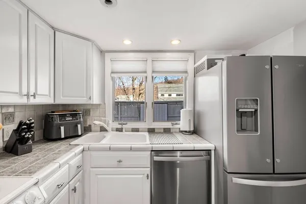 a living room with furniture a flat screen tv and a large window