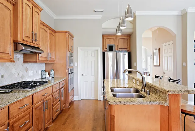 a kitchen with stainless steel appliances granite countertop a sink stove and refrigerator