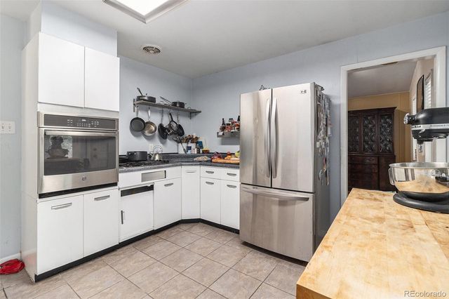 a kitchen with granite countertop a refrigerator and a sink